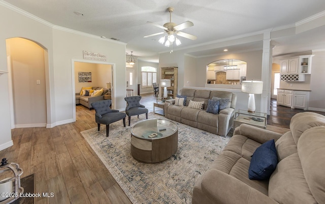 5004 County Rd 1430, Lubbock, TX 79407 - living room with arched walkways, ornamental molding, baseboards, ceiling fan, and wood-type flooring