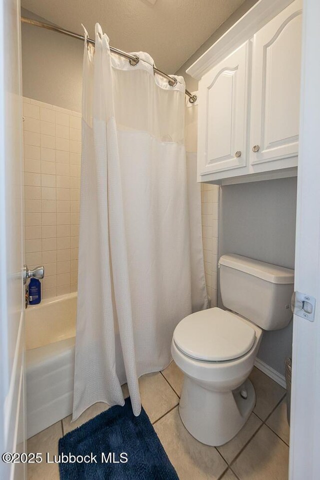 5004 County Rd 1430, Lubbock, TX 79407 - bathroom featuring toilet, tile patterned flooring, and shower / bathtub combination with curtain