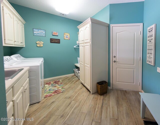 5004 County Rd 1430, Lubbock, TX 79407 - laundry room with cabinet space, washer and dryer, and light wood-style floors