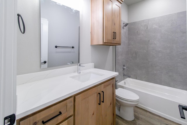 full bathroom featuring vanity, tiled shower / bath combo, toilet, and hardwood / wood-style flooring