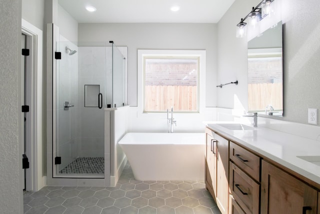 bathroom featuring plenty of natural light, independent shower and bath, and vanity