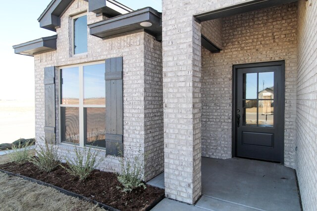 view of front of house featuring concrete driveway, brick siding, and an attached garage