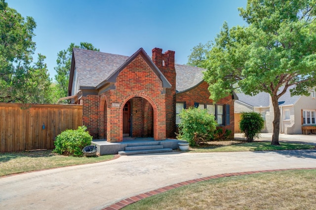 tudor-style house with a front lawn