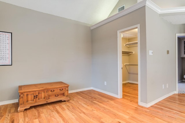 bedroom featuring lofted ceiling, a spacious closet, a closet, and light wood-type flooring