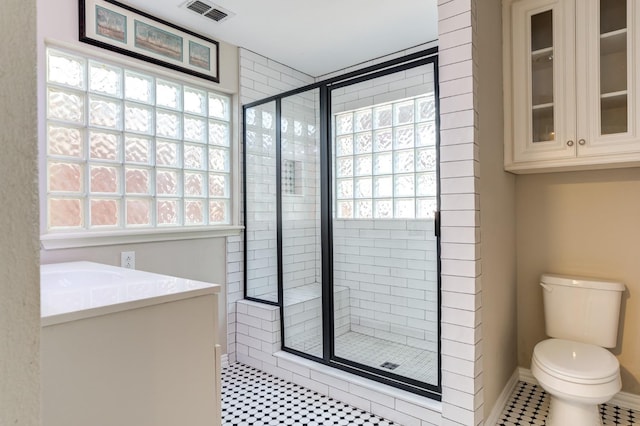 bathroom featuring plenty of natural light, toilet, and an enclosed shower