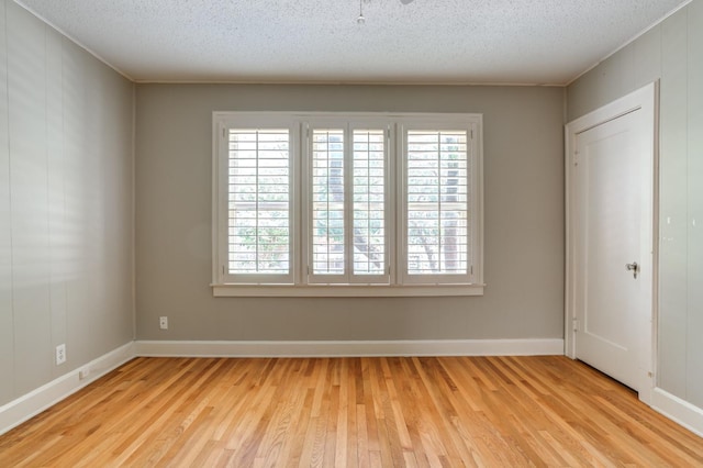 empty room featuring light hardwood / wood-style flooring and a textured ceiling