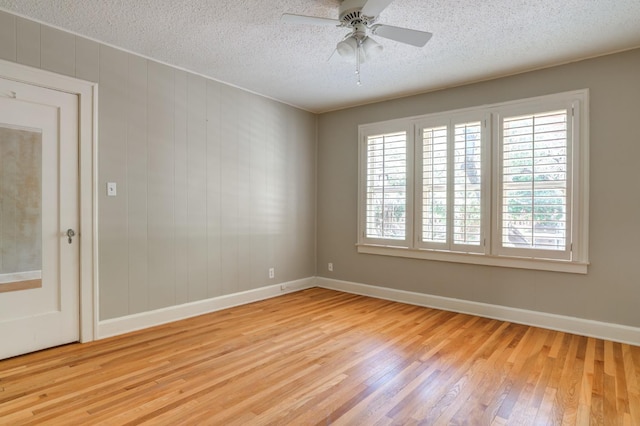 empty room with ceiling fan, a textured ceiling, and light hardwood / wood-style floors