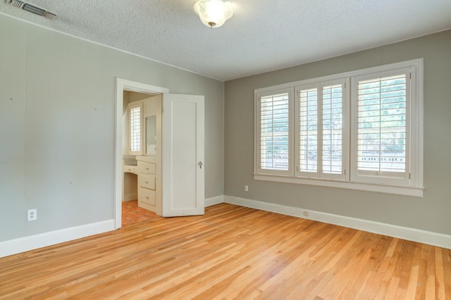 unfurnished bedroom featuring a textured ceiling and light wood-type flooring