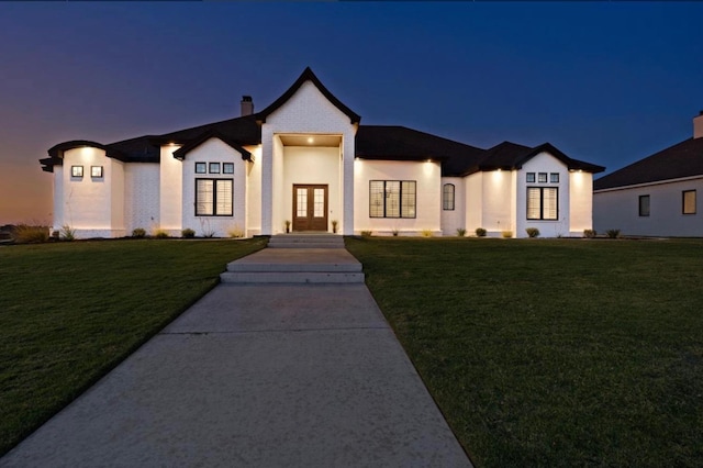 view of front of home featuring a yard and french doors