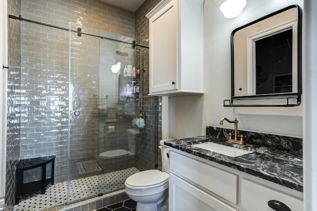 bathroom with vanity, a shower with shower door, and toilet