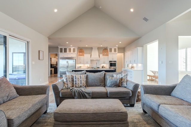 living room featuring a wealth of natural light and high vaulted ceiling