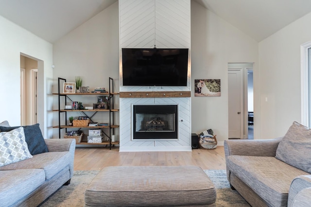 living room with hardwood / wood-style flooring, a fireplace, and vaulted ceiling