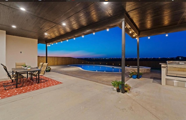 pool at dusk featuring a patio