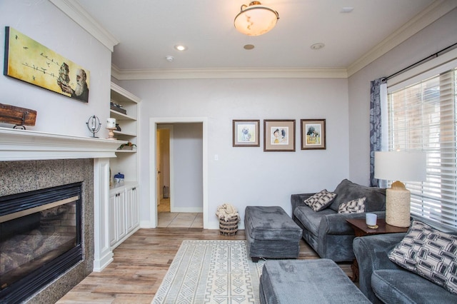 living room featuring crown molding, built in shelves, and light wood-type flooring