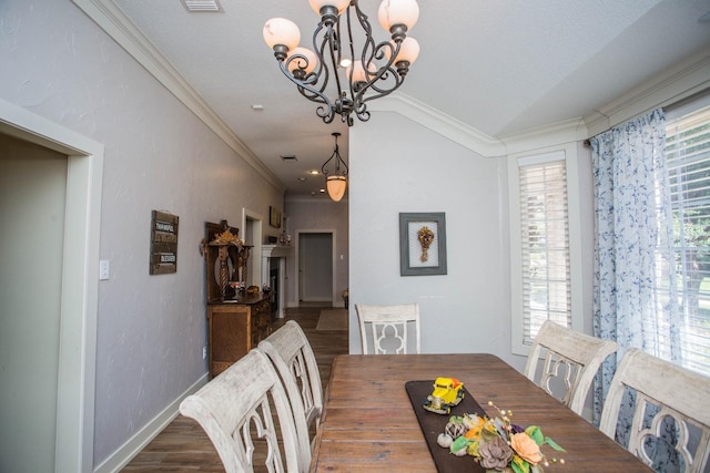 dining area with ornamental molding, vaulted ceiling, a healthy amount of sunlight, and wood-type flooring