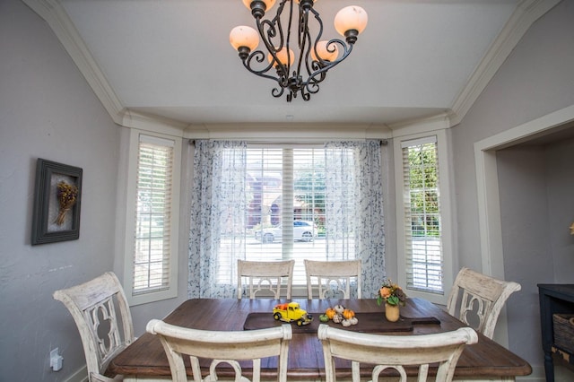 dining space with a notable chandelier, crown molding, and a healthy amount of sunlight