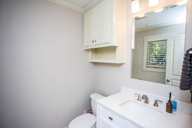 bathroom featuring vanity, crown molding, and toilet