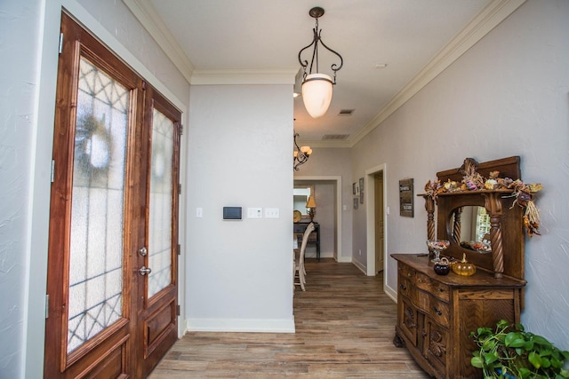 entryway featuring hardwood / wood-style floors, crown molding, french doors, and a healthy amount of sunlight