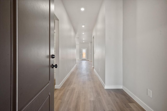 hallway with light hardwood / wood-style floors