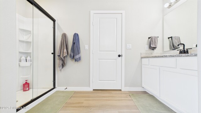 1105 Cajun St, Odessa, TX 79765 - full bath featuring vanity, wood finished floors, baseboards, and a shower stall