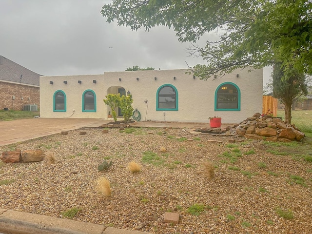 southwest-style home featuring central AC unit