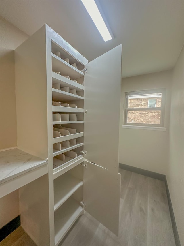 walk in closet with light wood-type flooring