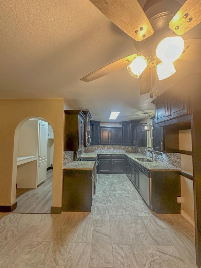 kitchen with stainless steel appliances, dark brown cabinets, sink, and a textured ceiling