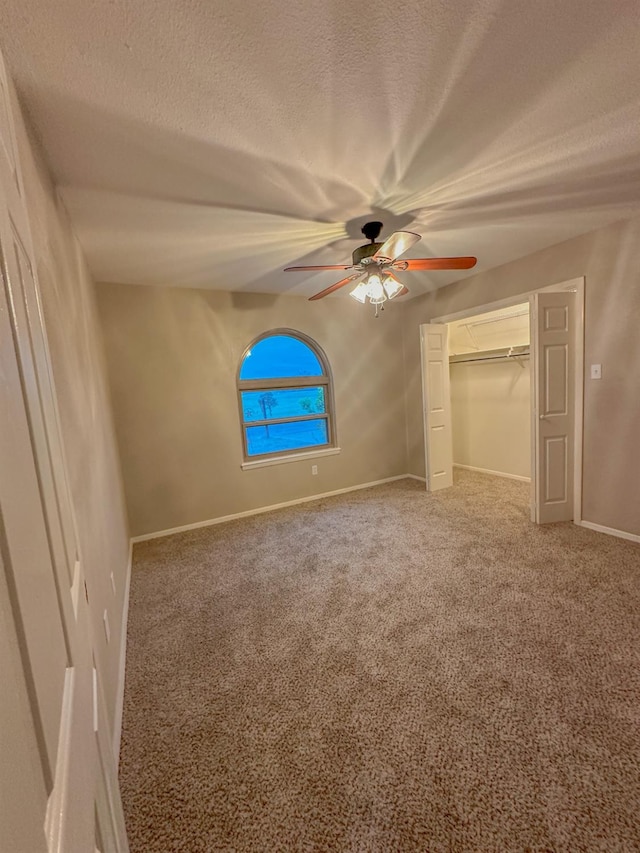 unfurnished bedroom featuring ceiling fan, a closet, carpet, and a textured ceiling