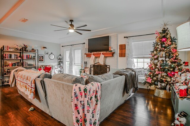 living room with dark hardwood / wood-style flooring, a brick fireplace, and ceiling fan