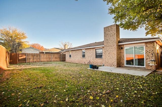 rear view of property featuring a patio and a lawn