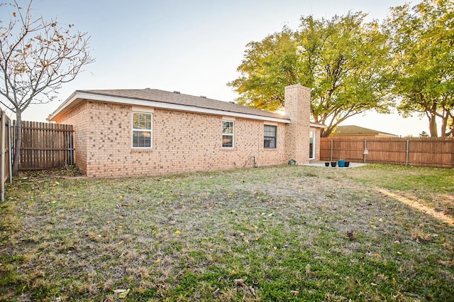 back of property featuring a lawn