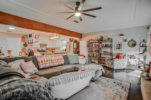 living room featuring dark wood-type flooring, ceiling fan, and beamed ceiling