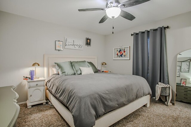 bedroom with ceiling fan and dark colored carpet