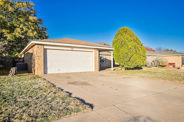 view of front facade with central AC unit, a garage, and a front yard