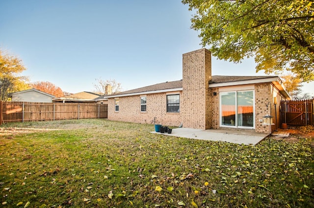 rear view of house with a lawn and a patio