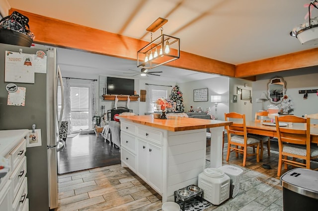 kitchen featuring white cabinetry, a wealth of natural light, butcher block countertops, and stainless steel refrigerator