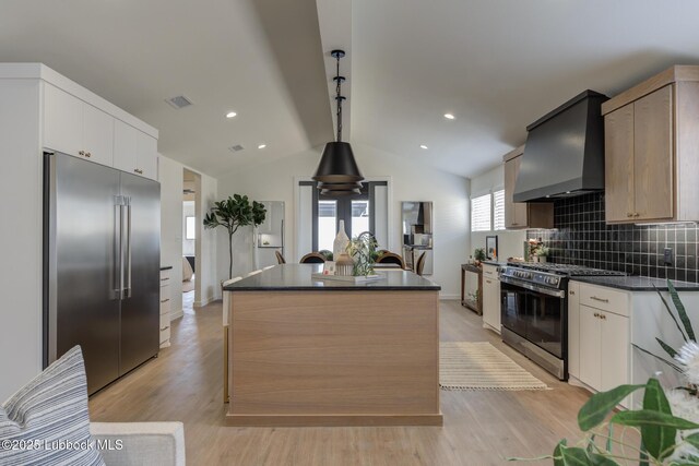 3617 127th St, Lubbock, TX 79423 - kitchen featuring appliances with stainless steel finishes, custom range hood, dark countertops, a center island, and backsplash