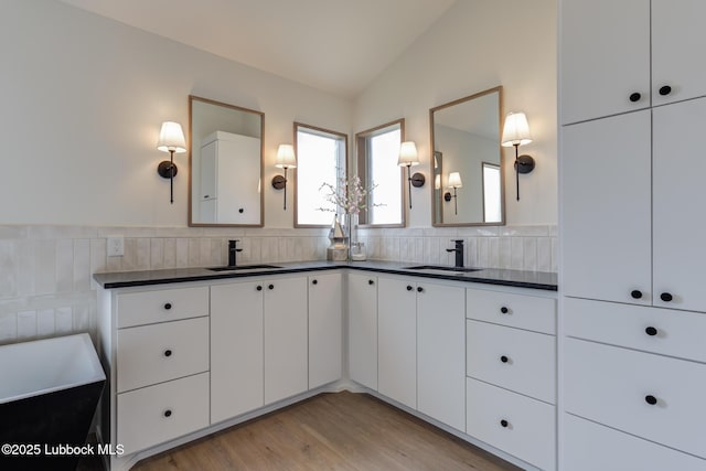 3617 127th St, Lubbock, TX 79423 - bathroom with double vanity, wood finished floors, a bath, tile walls, and lofted ceiling