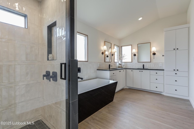3617 127th St, Lubbock, TX 79423 - bathroom with double vanity, healthy amount of natural light, lofted ceiling, a freestanding bath, and a shower stall