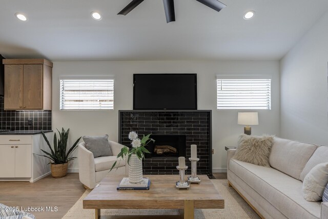 3617 127th St, Lubbock, TX 79423 - living area with light wood-type flooring, a ceiling fan, a tiled fireplace, and recessed lighting