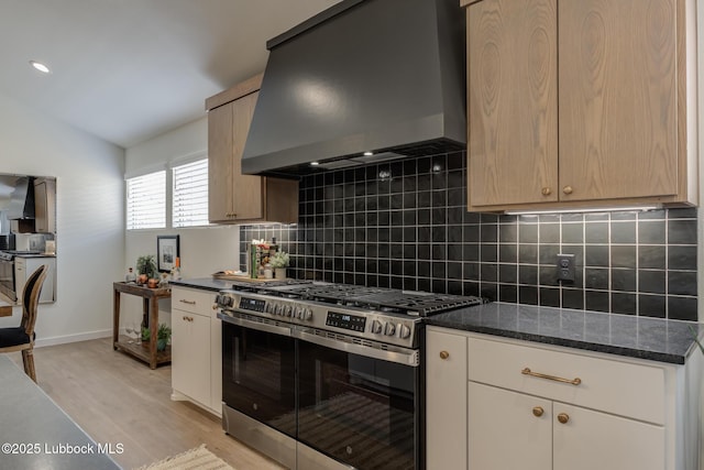 3617 127th St, Lubbock, TX 79423 - kitchen with stainless steel gas range oven, wall chimney range hood, light wood-style floors, backsplash, and dark stone countertops
