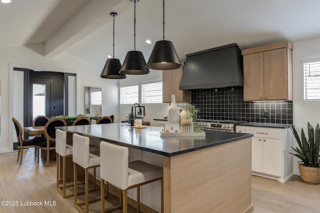 3617 127th St, Lubbock, TX 79423 - kitchen featuring custom range hood, a kitchen island with sink, tasteful backsplash, and healthy amount of natural light