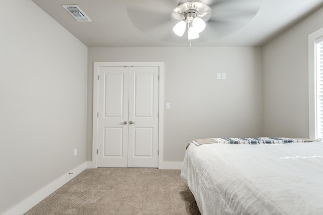 carpeted bedroom with ceiling fan and a closet