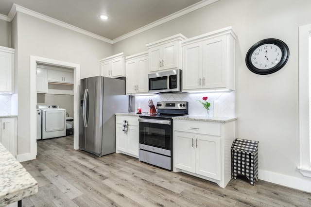 kitchen with white cabinetry, stainless steel appliances, crown molding, washer and clothes dryer, and light hardwood / wood-style flooring