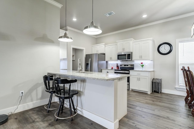 kitchen with pendant lighting, stainless steel appliances, tasteful backsplash, light stone countertops, and white cabinets