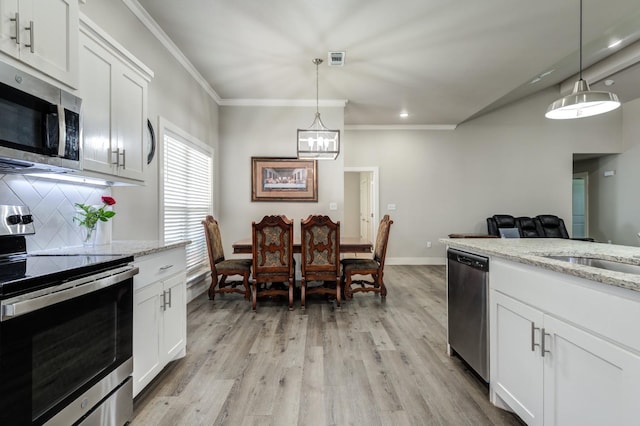 kitchen with white cabinetry, pendant lighting, light stone countertops, and appliances with stainless steel finishes