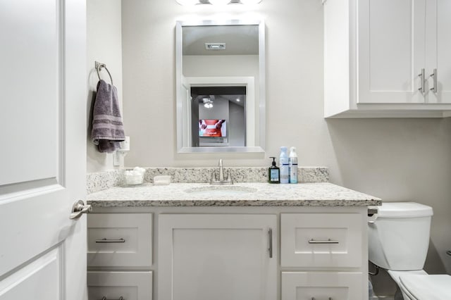 bathroom featuring vanity and toilet