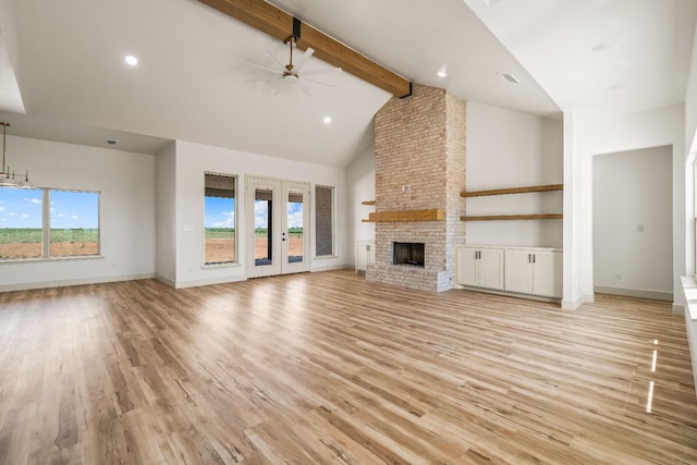 unfurnished living room featuring light hardwood / wood-style flooring, ceiling fan, beam ceiling, high vaulted ceiling, and a fireplace