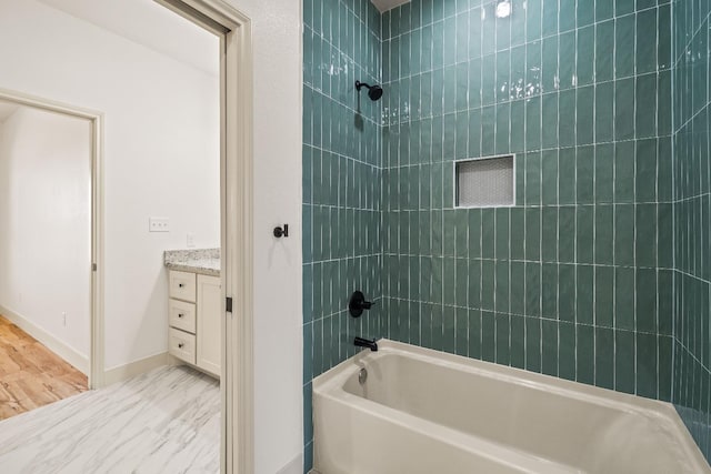 bathroom featuring tiled shower / bath combo and vanity