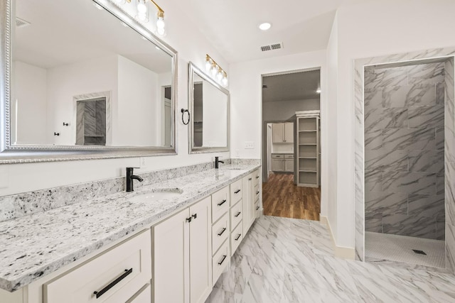 bathroom featuring tiled shower and vanity